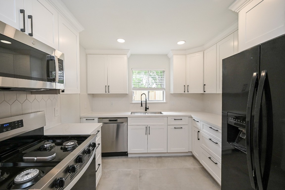 11027 Maize Lane Houston, TX 77041 - Photo 10 of 32 a kitchen with stainless steel appliances a sink stove and refrigerator