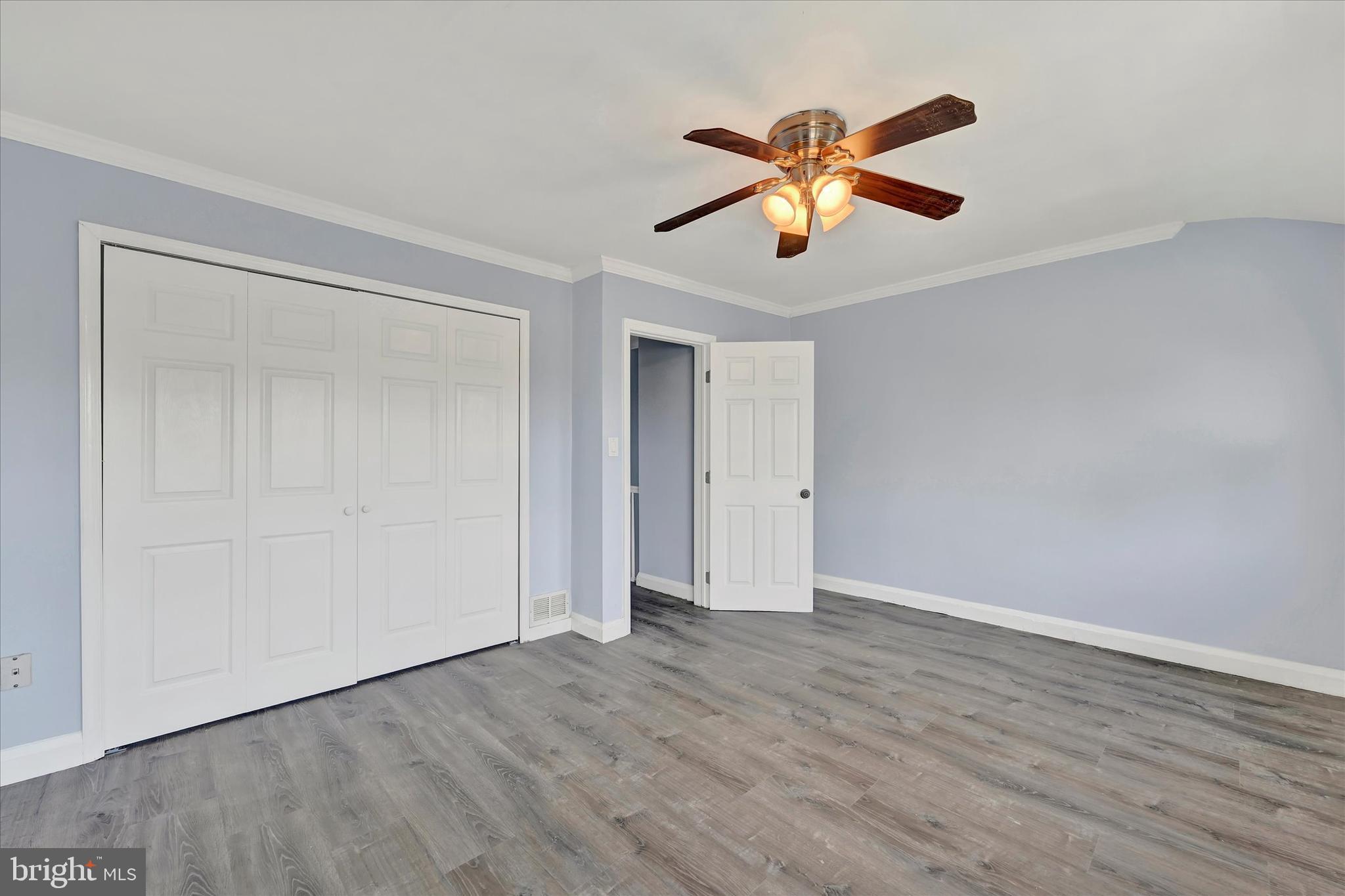 7954 Kavanagh Road Baltimore, MD 21222 - Photo 11 of 16 a view of an empty room with wooden floor and a ceiling fan