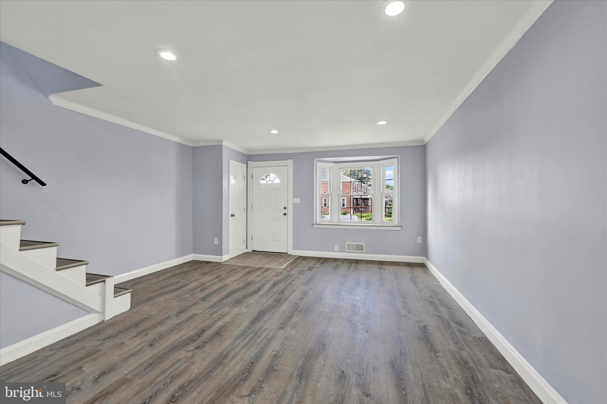 7954 Kavanagh Road Baltimore, MD 21222 - Photo 4 of 16 an empty room with wooden floor and windows