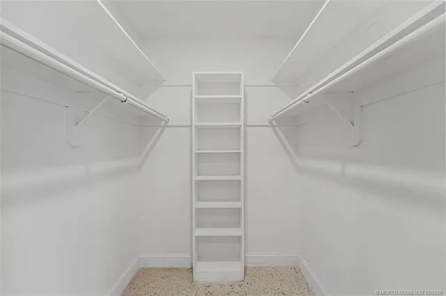 a view of walk in closet with empty racks