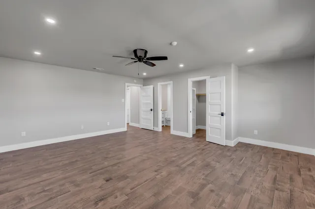 a bathroom with a granite countertop toilet a sink a mirror and bathtub