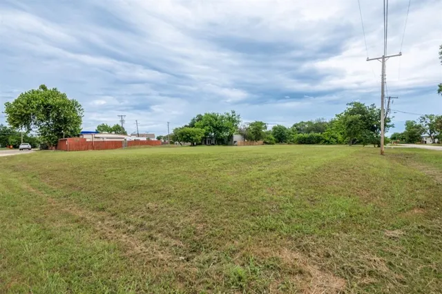 a view of a field with an trees in the background