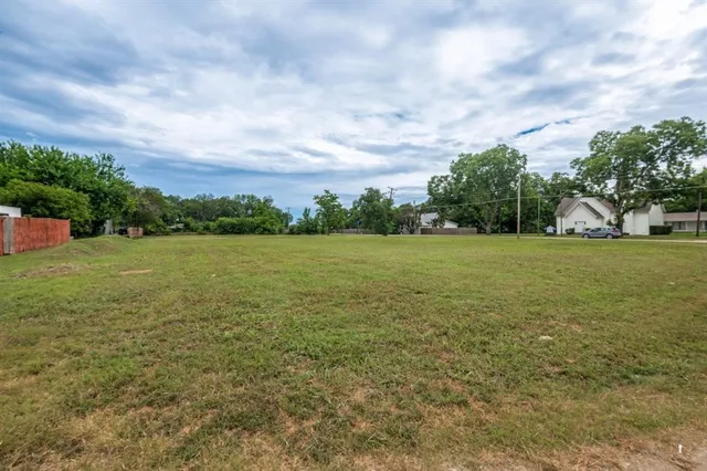 a view of a field with an trees in the background