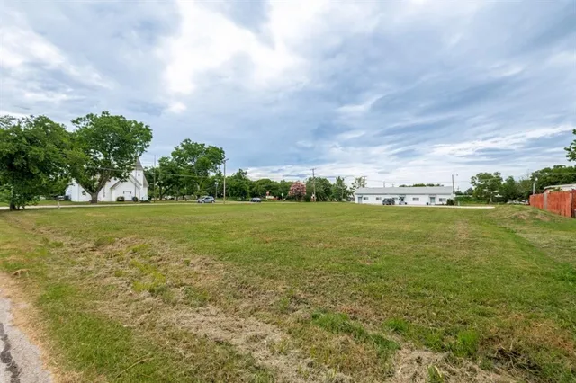 a view of a green field with wooden fence
