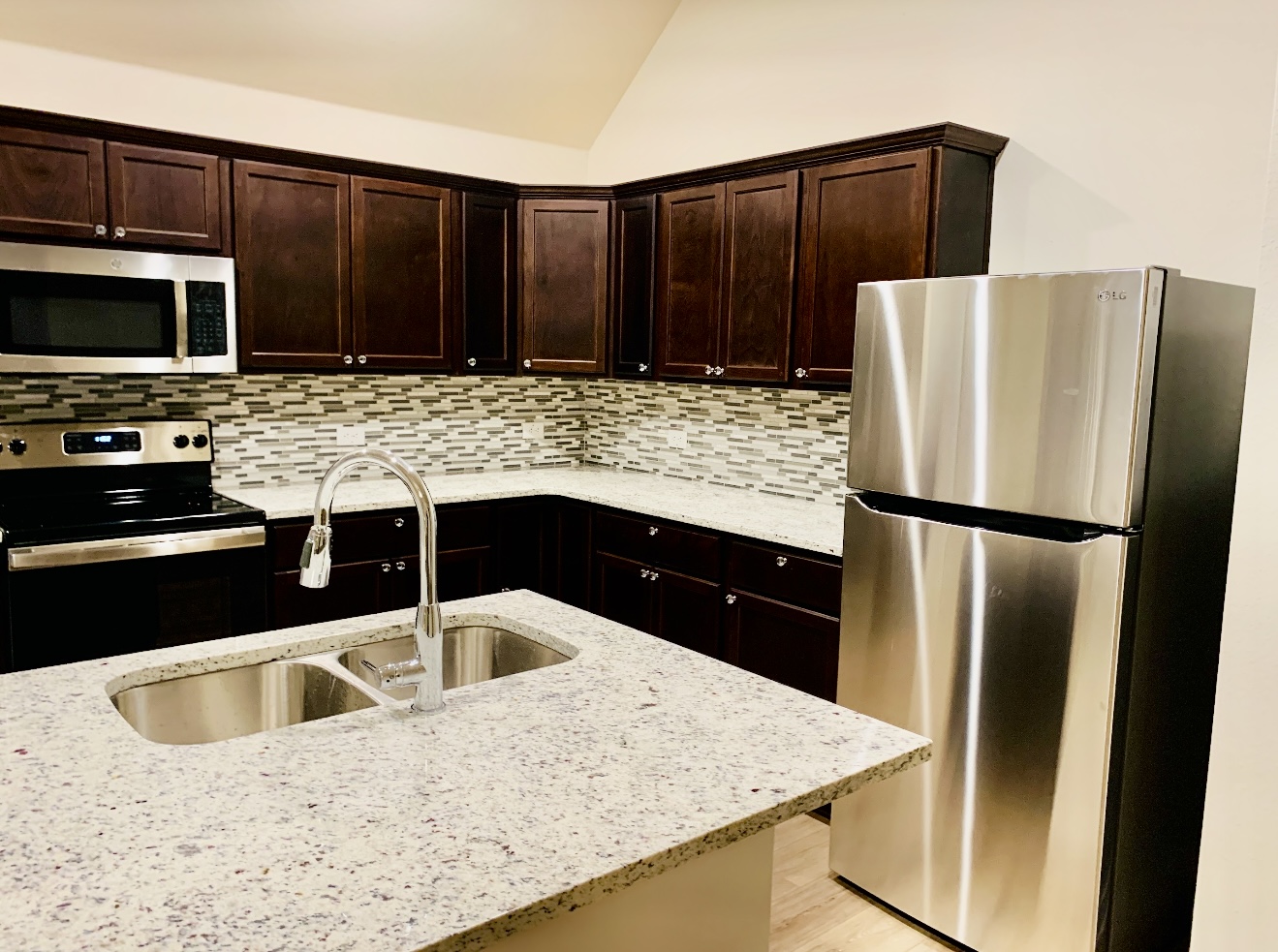 808 Fallbrook Drive Temple, TX 76502 - Photo 4 of 36 Kitchen with stainless steel appliances, dark brown cabinets, tasteful backsplash, and lofted ceiling