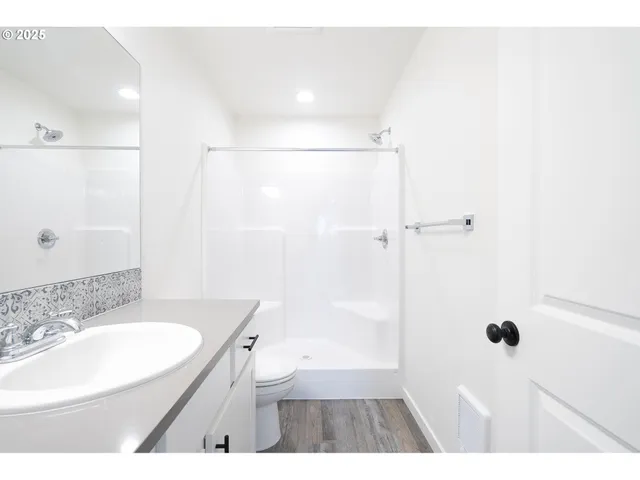 a bathroom with a sink a toilet a shower and a mirror