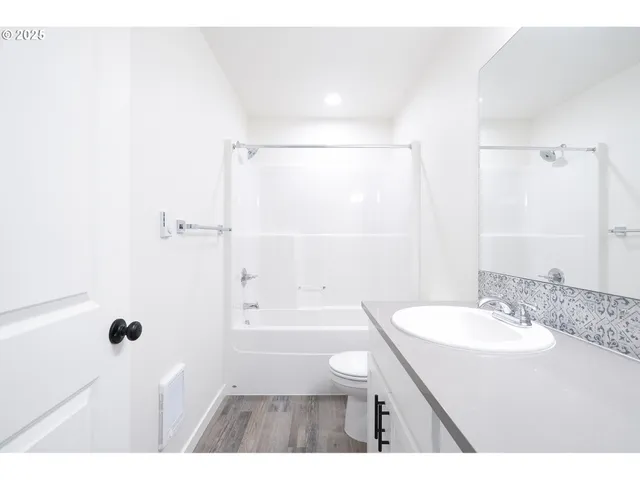 a bathroom with a sink a toilet a shower and a mirror