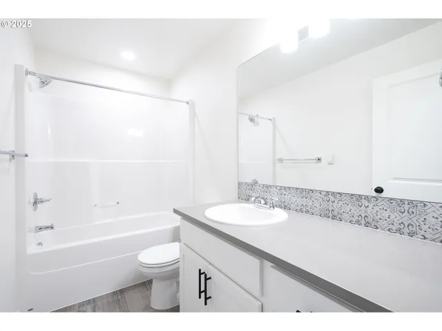 a bathroom with a granite countertop sink a toilet and bathtub