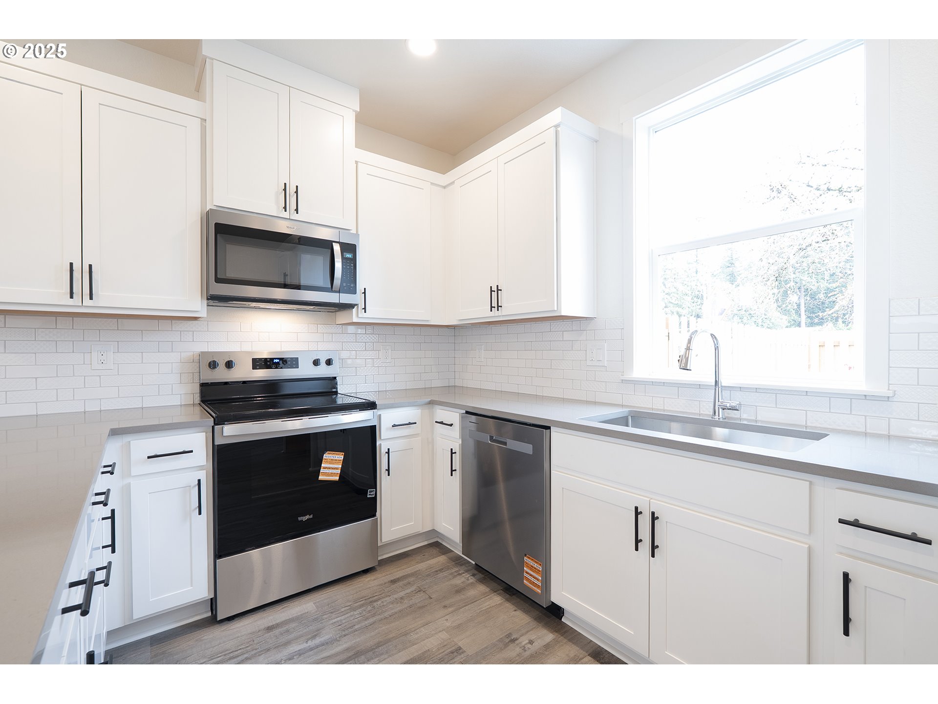 14722 Southeast Powell Boulevard Portland, OR 97236 - Photo 7 of 20 a kitchen with stainless steel appliances granite countertop a sink a stove a microwave and wooden cabinets