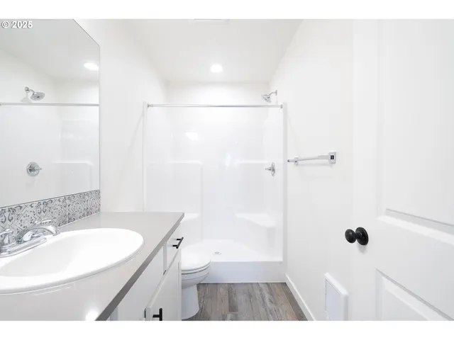 a bathroom with a sink a toilet a shower and a mirror