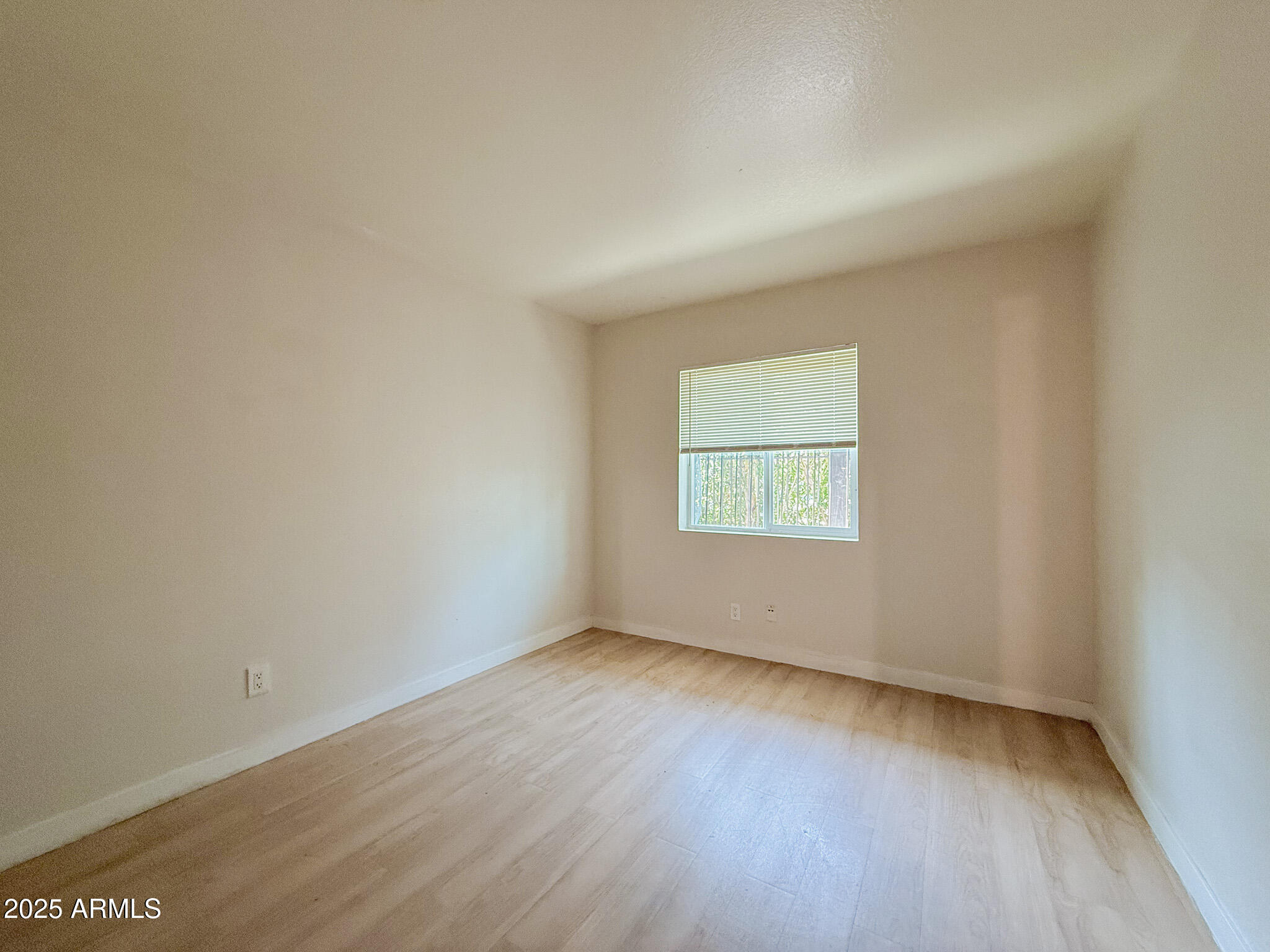 1703 West Mountain View Road, Unit 11 Phoenix, AZ 85021 - Photo 11 of 12 an empty room with wooden floor and windows