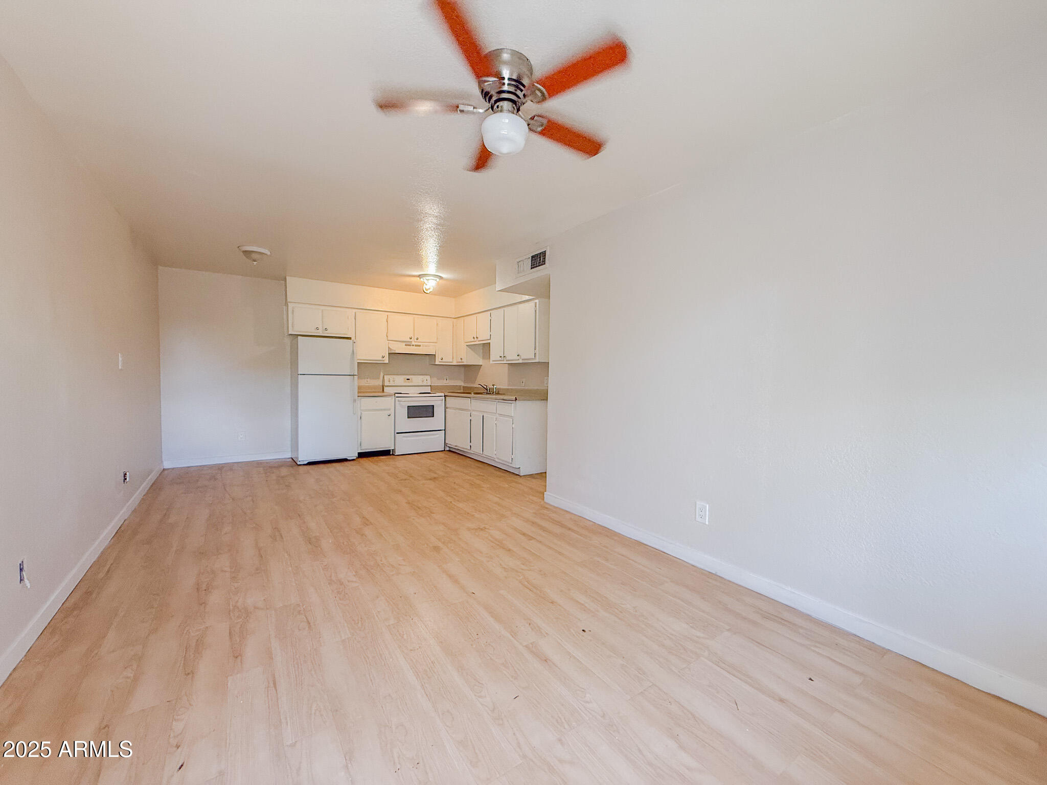 1703 West Mountain View Road, Unit 11 Phoenix, AZ 85021 - Photo 6 of 12 a view of empty room with wooden floor and fan