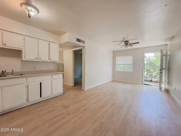 a view of a kitchen with a sink and dishwasher with wooden floor