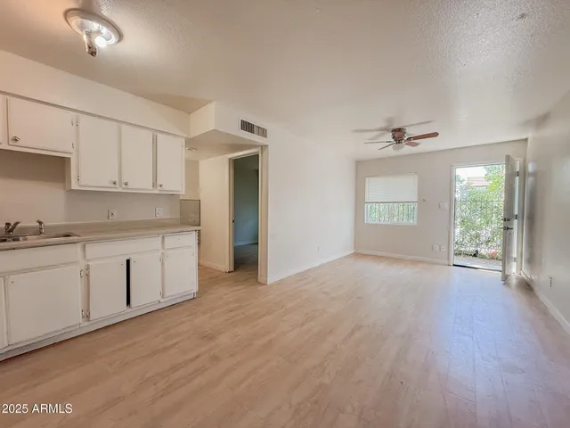 a view of a kitchen with a sink and dishwasher with wooden floor