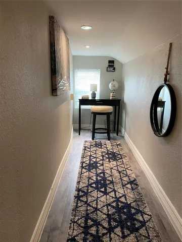 a bedroom with a bed and a lamp on dresser