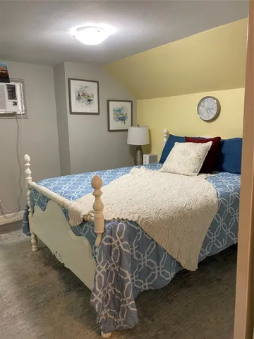 a bedroom with a bed and painting on the wall