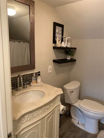 a bathroom with a granite countertop toilet sink and mirror