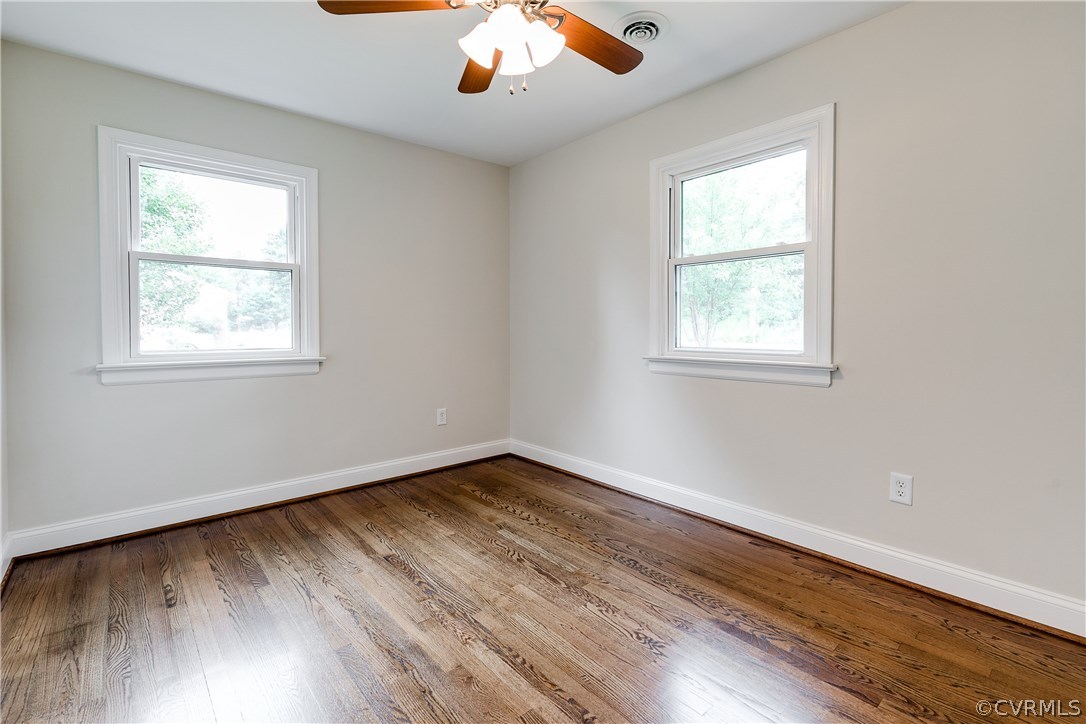 10707 River Road Chesterfield, VA 23838 - Photo 20 of 27 an empty room with wooden floor chandelier fan and windows