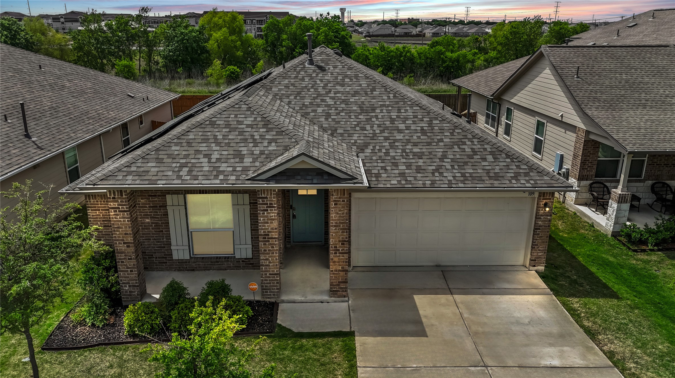 109 Rochester Lane Hutto, TX 78634 - Photo 1 of 1 Ranch-style house with brick siding, an attached garage, a shingled roof, and driveway