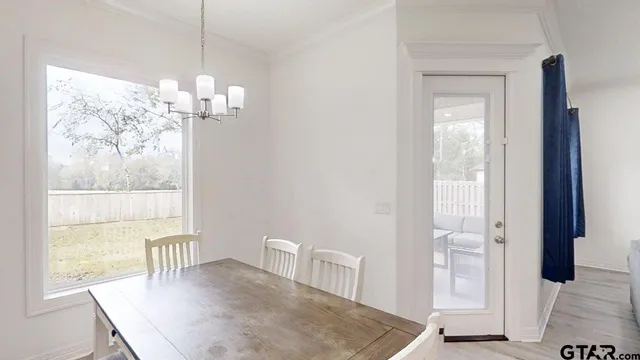 a view of a dining room with furniture wooden floor and chandelier