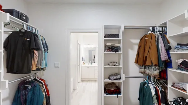 a view of walk in closet with clothes and shoes