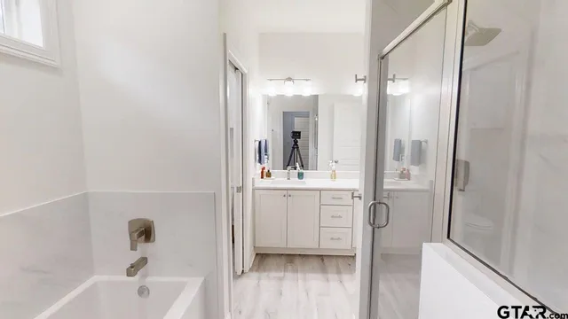 a bathroom with a bathtub shower sink a toilet and a mirror