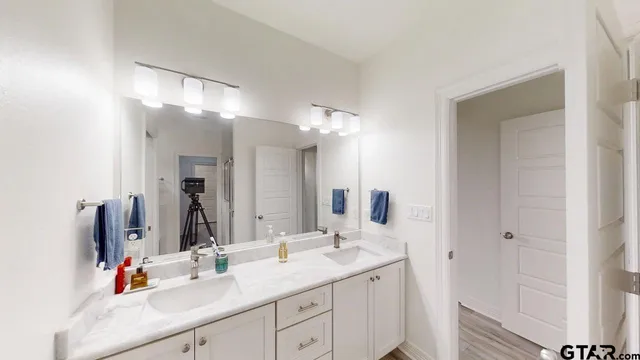 a bathroom with a double vanity sink and a mirror