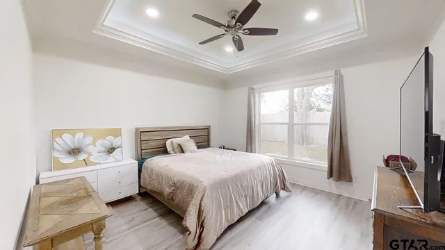 a bedroom with a bed table and a flat screen tv
