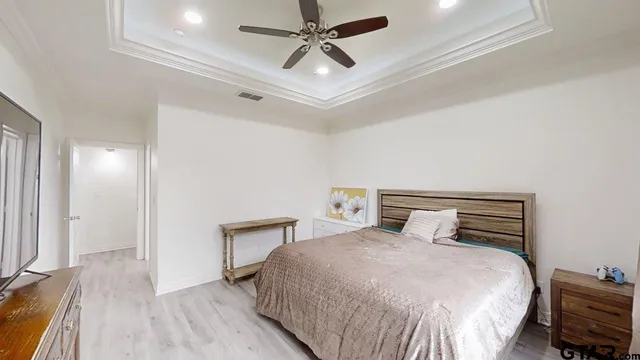 a bedroom with a bed and a ceiling fan