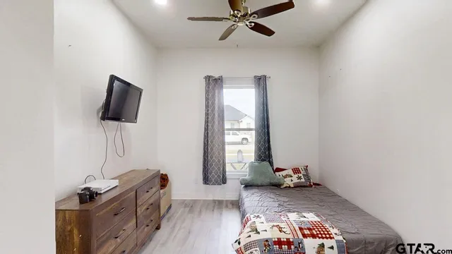 a bedroom with a bed and wooden floor