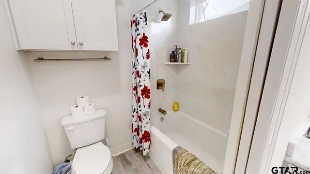 a white toilet sitting next to a shower