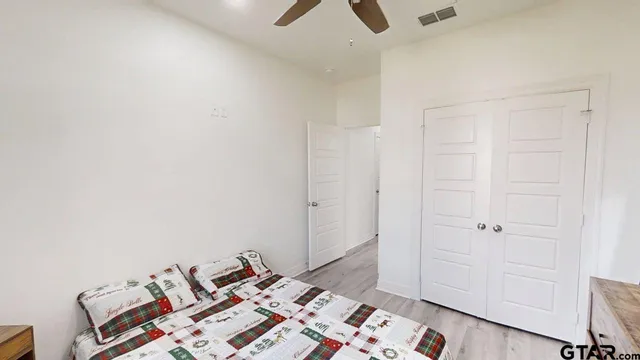 an empty room with bed and wooden floor