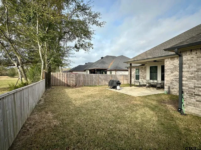 a view of a house with backyard and sitting area