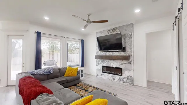 a living room with furniture a flat screen tv and a fireplace