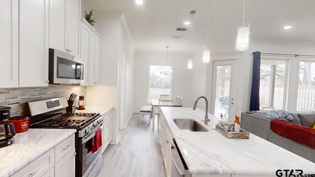 a kitchen with kitchen island a sink stove top oven and microwave