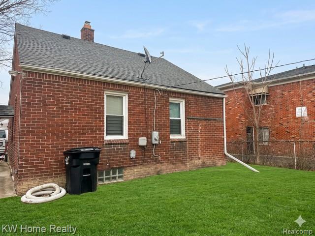 4607 Cadieux Road Detroit, MI 48224 - Photo 16 of 18 Back of property with a chimney, brick siding, and roof with shingles