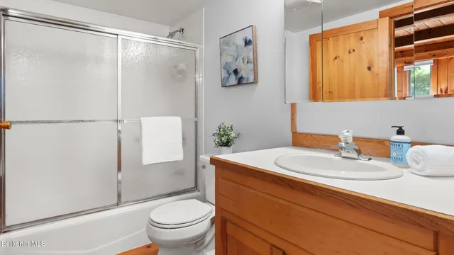 a bathroom with a granite countertop sink toilet and shower