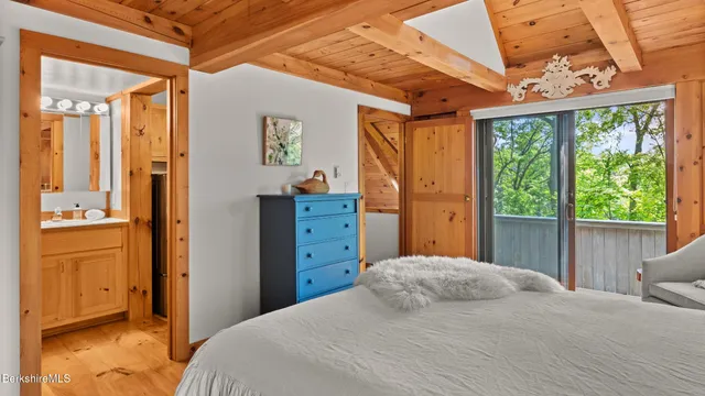 a bedroom with a bed and large windows
