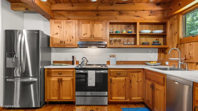 a kitchen with stainless steel appliances granite countertop a refrigerator and a sink