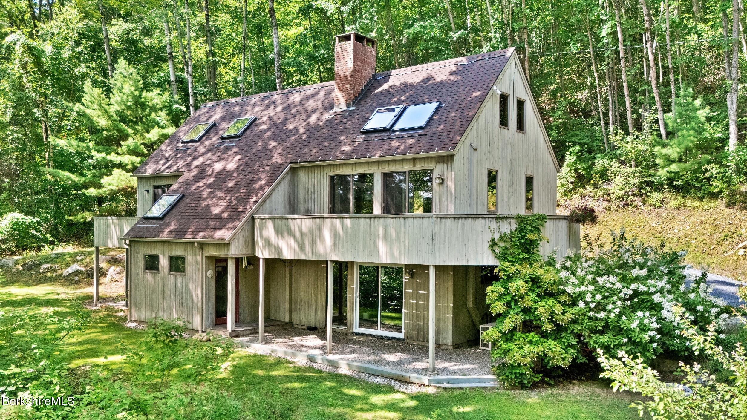 85 Main Road Monterey, MA 01230 - Photo 4 of 32 a front view of a house with a garden