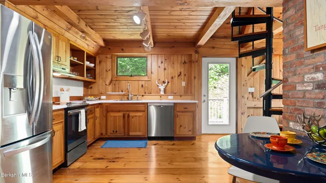 a kitchen with stainless steel appliances granite countertop a sink a stove and a refrigerator