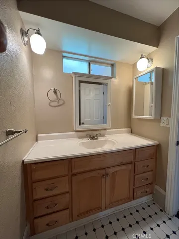a bathroom with a granite countertop sink and a mirror