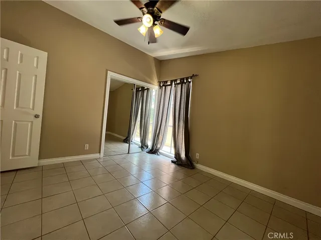 an empty room with closet and a chandelier fan