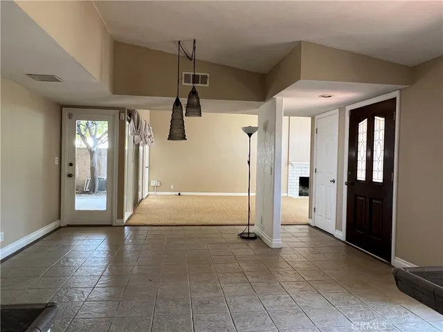 a view of a hallway with wooden floor and a living room