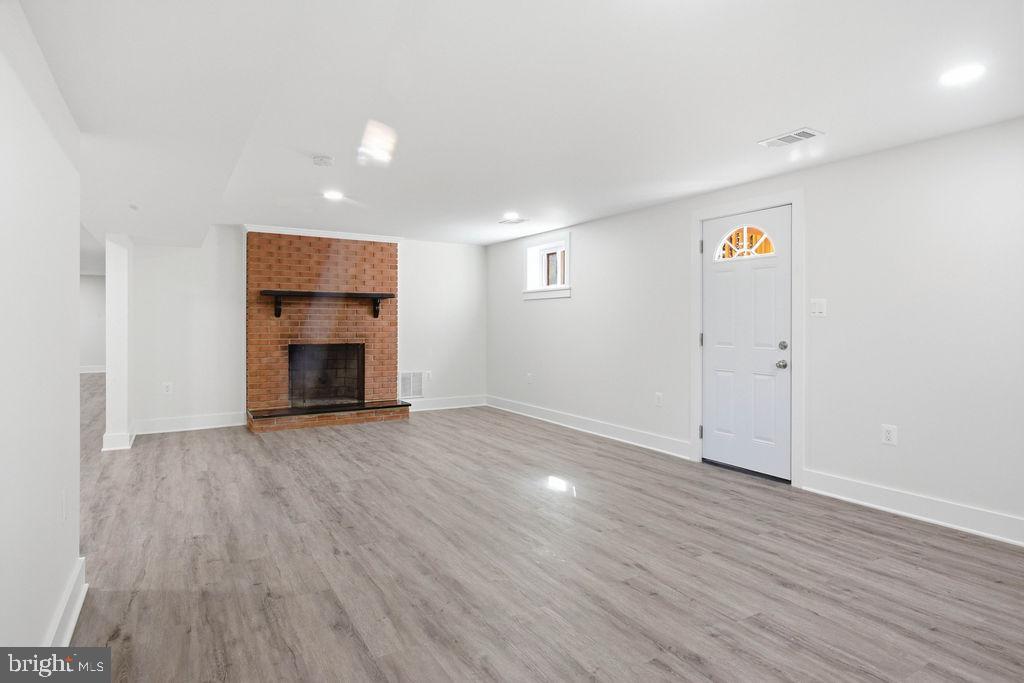 6620 Napoli Road Temple Hills, MD 20748 - Photo 29 of 38 an empty room with wooden floor fireplace and windows