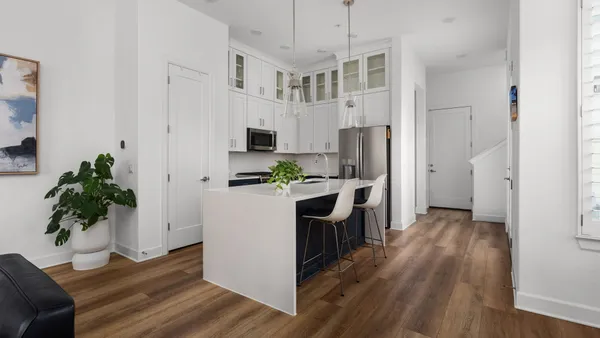 a kitchen with stainless steel appliances a refrigerator a stove a sink cabinets and wooden floor