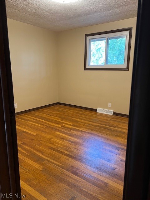 10157 Ravenna Road Chardon, OH 44024 - Photo 19 of 34 Empty room featuring dark hardwood / wood-style flooring and a textured ceiling
