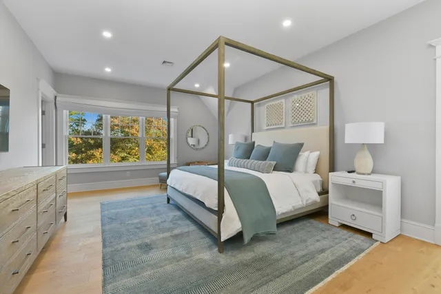 a spacious bedroom with a bed and a large window