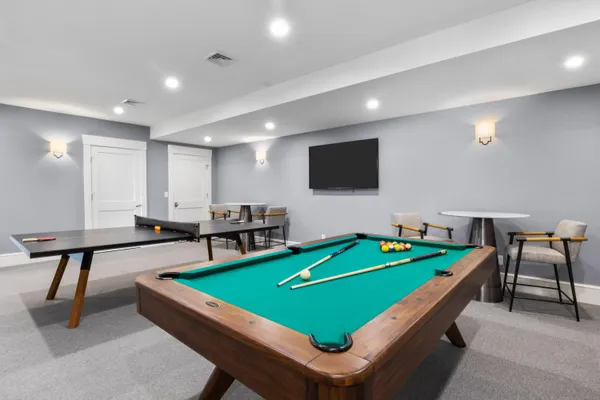 a room with pool table and windows