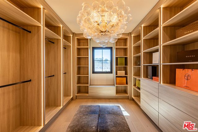 a large room with kitchen island stainless steel appliances wooden floor and living room view